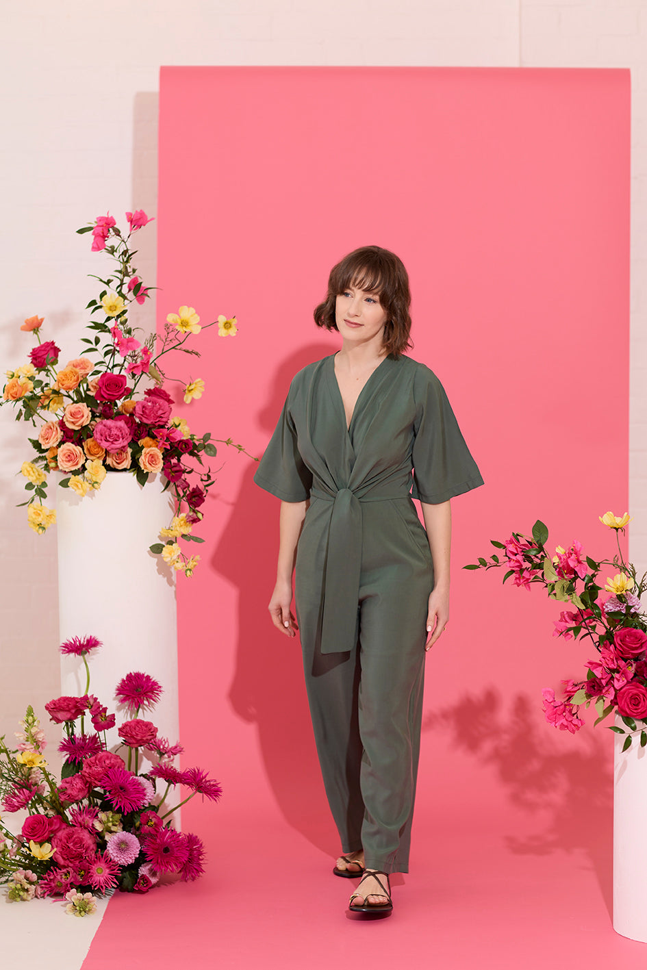 Wide leg, short sleeve petite jumpsuit in green, worn by model walking