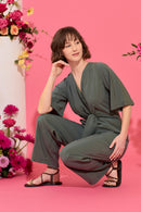 Wide leg, short sleeve petite jumpsuit in green, worn by model crouching