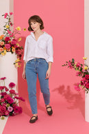 Slim, straight, high rise blue petite jeans worn by model walking
