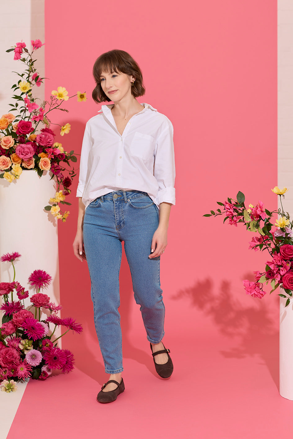 Slim, straight, high rise blue petite jeans worn by model walking