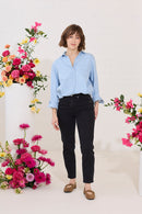 Slim, straight, high rise black petite jeans worn by model, front view