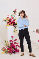 Slim, straight, high rise black petite jeans worn by model, front view