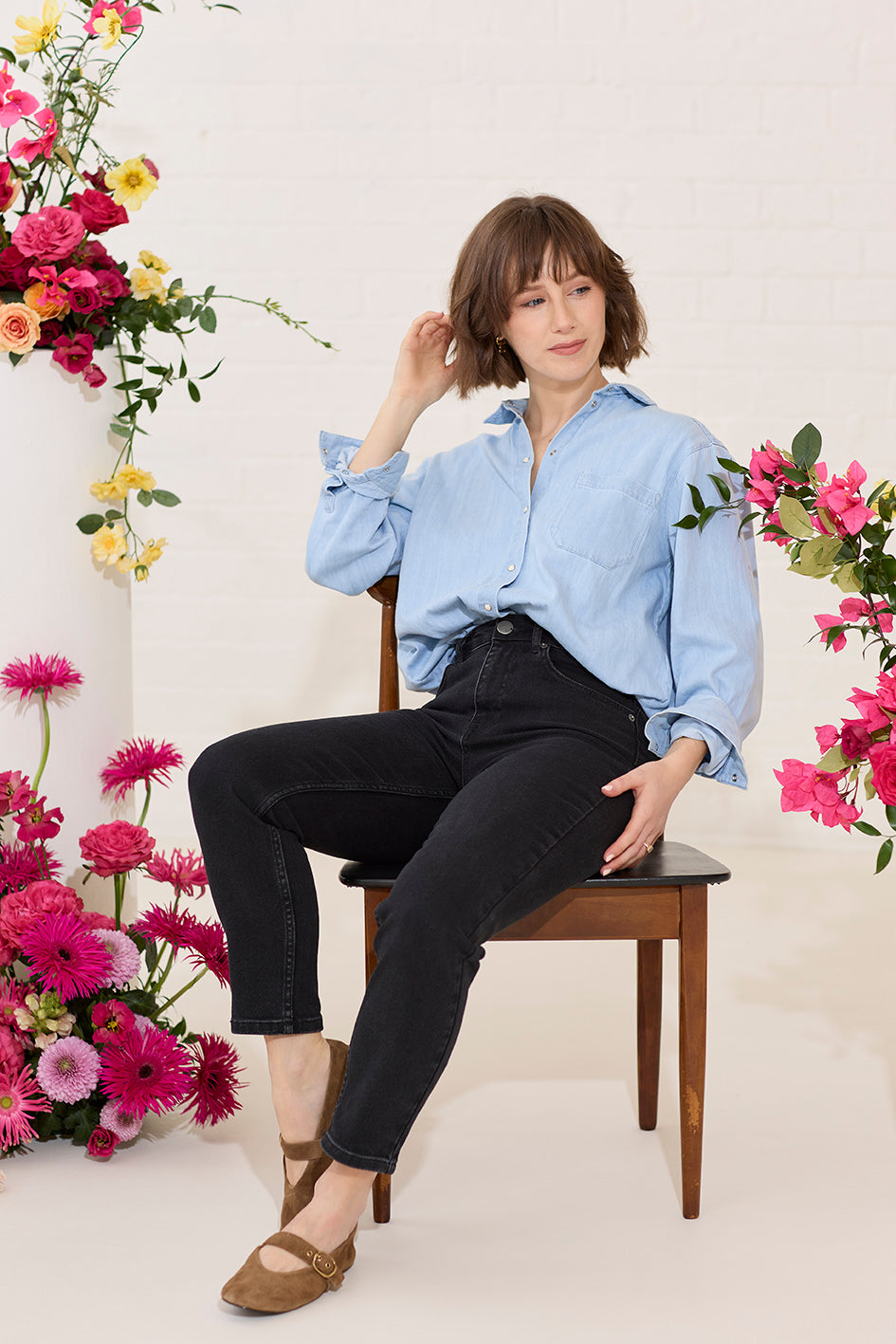 Slim, straight, high rise black petite jeans worn by model sat down