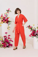 Wide leg, short sleeve petite jumpsuit in red, worn by model walking