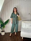Size 12 model wearing green petite wedding guest jumpsuit 