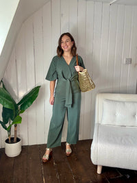 Size 12 model wearing green petite wedding guest jumpsuit 