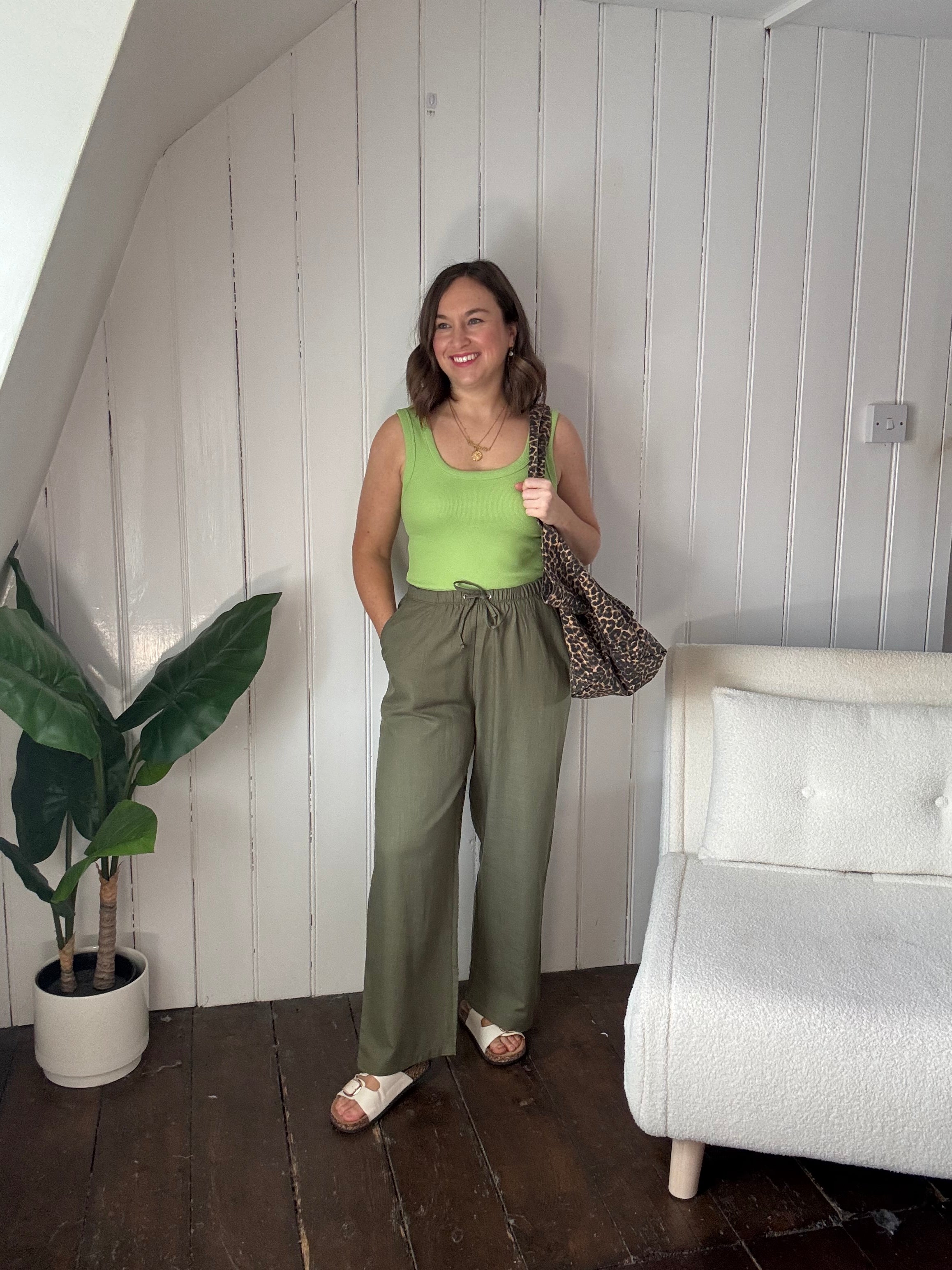 Size 12 model wearing petite khaki wide leg summer trousers styled casually