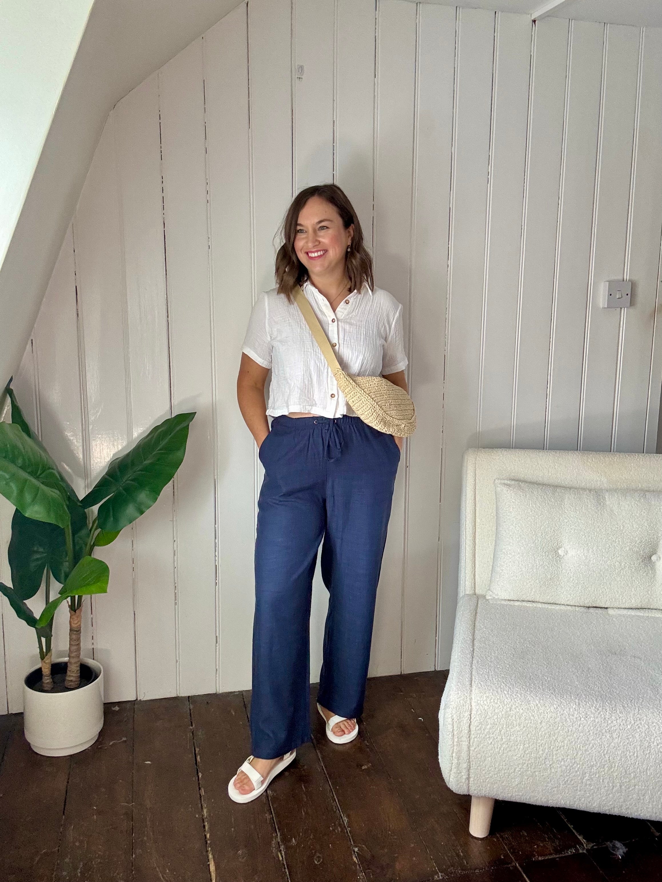 Size 12 model wearing petite navy wide leg summer trousers styled casually